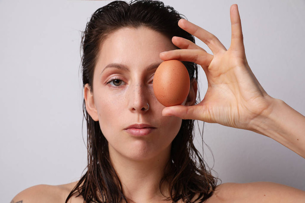 Young woman holding natural egg. Isolated. - Valokuva, kuva