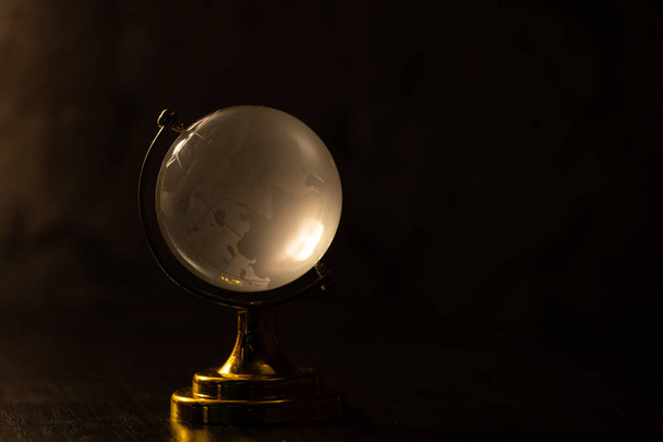 clear glass globe with blurred background on the table - Foto, imagen