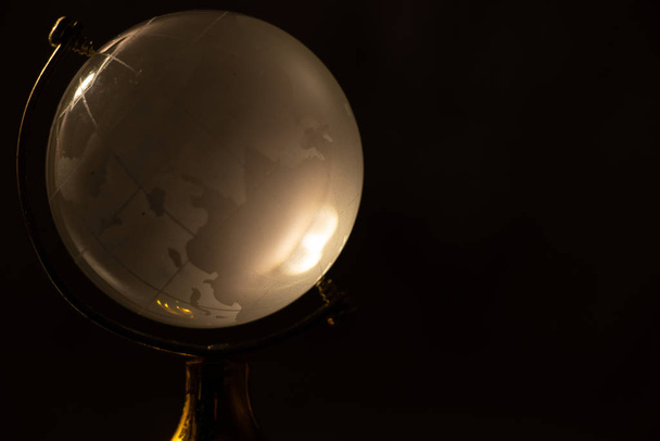 clear glass globe with blurred background on the table - Фото, зображення