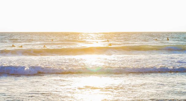 keskittämätön Välimeren meren rannalla aallot ja ihmiset siluetti vedessä kirkas auringonlasku aikaa auringon häikäisyn kuva, loma ja loma matkailutoimisto tapetti kuvio kuva
 - Valokuva, kuva