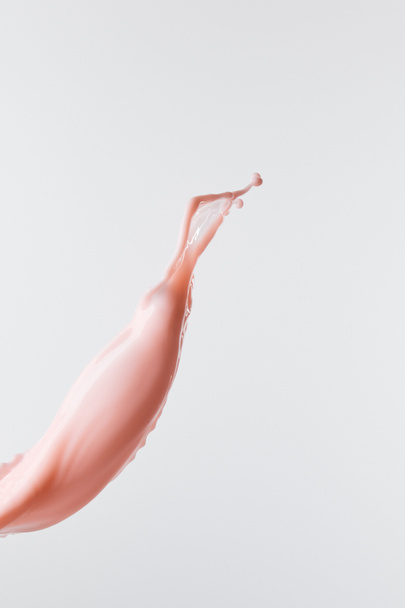 salpicadura de leche rosa fresca con gotas aisladas en blanco
 - Foto, Imagen