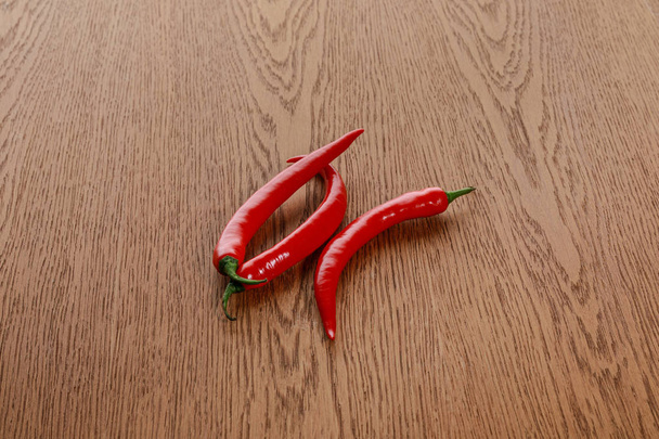 red spicy chili peppers on wooden brown table - Fotoğraf, Görsel