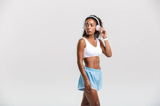 Portrait of african american woman listening music with headphones - Foto, afbeelding