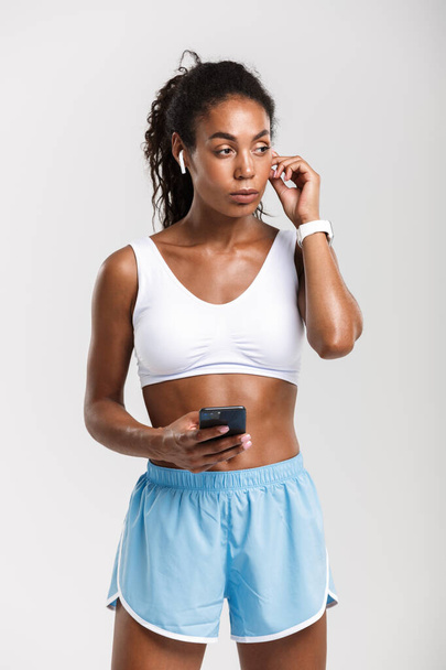 Portrait of african american woman using cellphone and earpods - Foto, Imagen