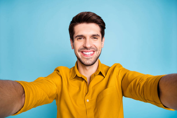 Self portrait of cute cheerful man having journey taking selfie smiling toothily in trip isolated over blue pastel color background - Fotoğraf, Görsel