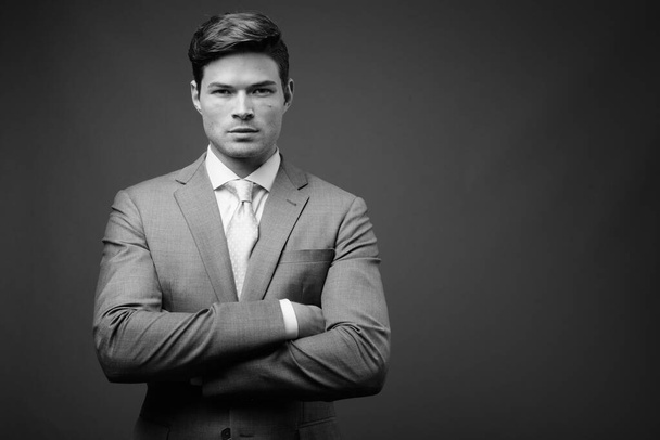 Studio shot of young handsome businessman in suit - Fotoğraf, Görsel