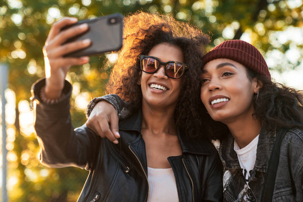 Image of two african american girls taking selfie on cellphone o - Fotografie, Obrázek