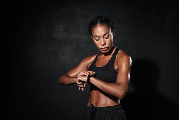 Attractive muscular young african sportswoman standing - Fotoğraf, Görsel