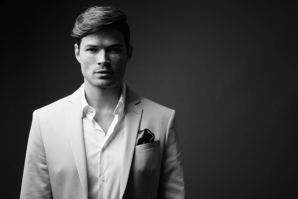 Studio shot of young handsome businessman in suit - Foto, Bild