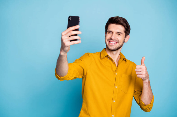 Portrait of his he nice attractive cheerful cheery glad guy taking making selfie showing thumbup isolated on bright vivid shine vibrant blue green turquoise color background - Zdjęcie, obraz
