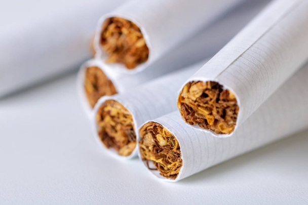 Крупный план кучи сигарет на белом фоне
 - Фото, изображение