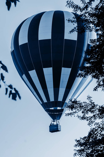 Heißluftballon fliegt bei Sonnenaufgang. getöntes Blau Trendfarbe des Jahres 2020 - Foto, Bild