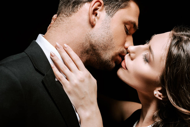 man kissing with beautiful woman isolated on black  - Zdjęcie, obraz