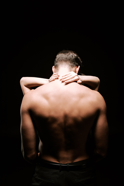 vista posteriore di uomo senza maglietta che abbraccia con donna isolata su nero
  - Foto, immagini