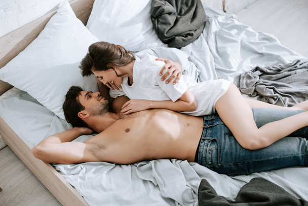 vista superior de la chica feliz acostado con un hombre guapo en la cama
  - Foto, Imagen