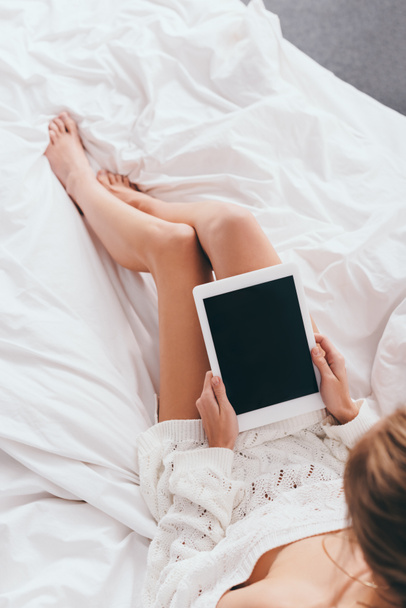 vista ritagliata della donna utilizzando tablet digitale con schermo bianco sul letto
 - Foto, immagini