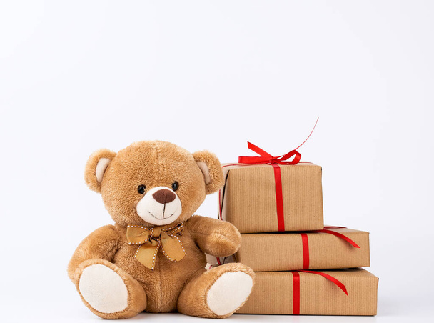 cute beige teddy bear and stack of gifts in boxes wrapped in bro - Foto, Imagem