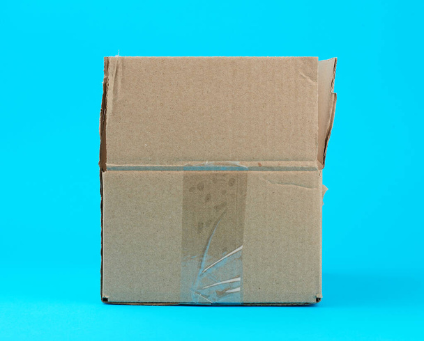 open brown cardboard box on a blue background - Fotoğraf, Görsel