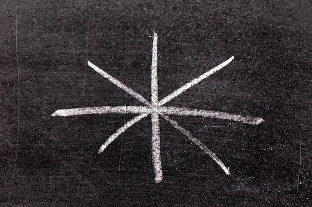 Λευκό σχέδιο χέρι κιμωλία σε σχήμα αστερίσκο σε μαύρο φόντο του σκάφους - Φωτογραφία, εικόνα
