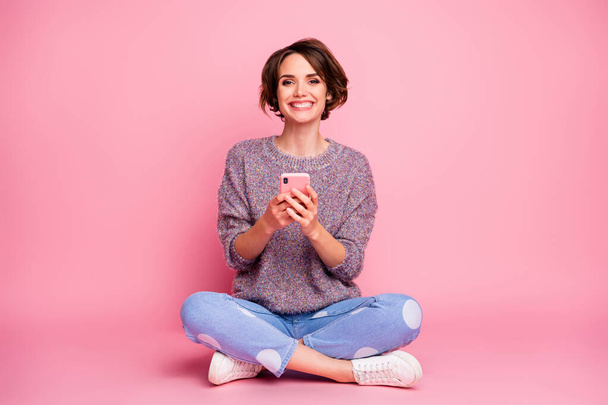 Portrait of her she nice-looking attractive lovely charming pretty cute cheerful cheery brown-haired girl sitting in lotus pose using 5g app isolated over pink pastel color background - Foto, Imagem