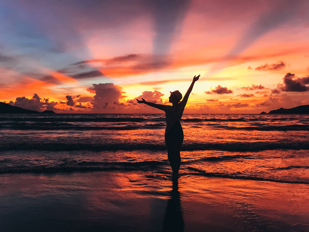 silhouette of beautiful young woman on seashore on sunset - Фото, зображення