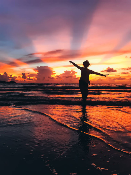 silhouette of beautiful young woman on seashore on sunset - Фото, зображення
