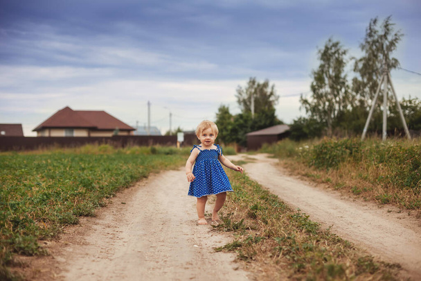 Tout-petit fille courir pieds nus sur la route du village
.  - Photo, image