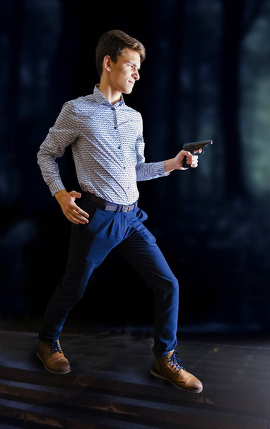 Man in shirt and jeans pointing gun, armed robbery at night or contract killing, - Фото, изображение