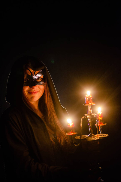 загадочная девушка в черном плаще, шабаш ведьмы в лесу ночью у костра - Фото, изображение
