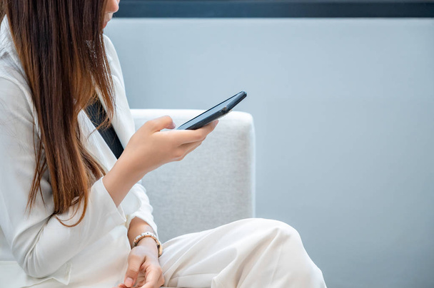 Mulheres de negócios usam roupas brancas felizes em jogar celular em um fundo branco
 - Foto, Imagem