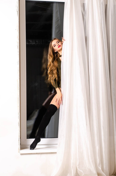 Сексуальна молода жінка в чорній чуттєвій білизні. Дівчина позує на цегляній стіні в студії
. - Фото, зображення