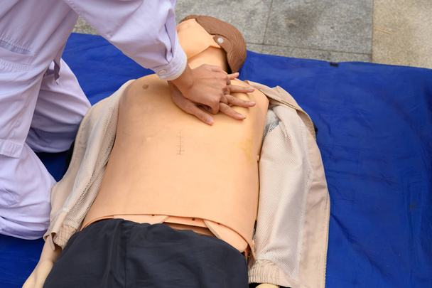 Enfermera demostrando reanimación cardiopulmonar en un modelo humano ficticio
 - Foto, Imagen