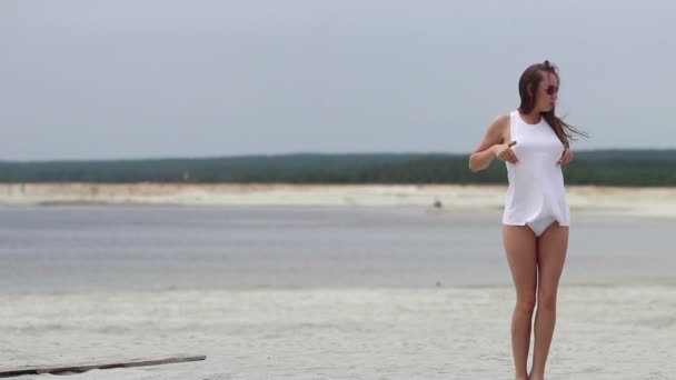 Kuuma nainen nauttivasti kävely varpaillaan hiekassa
 - Materiaali, video