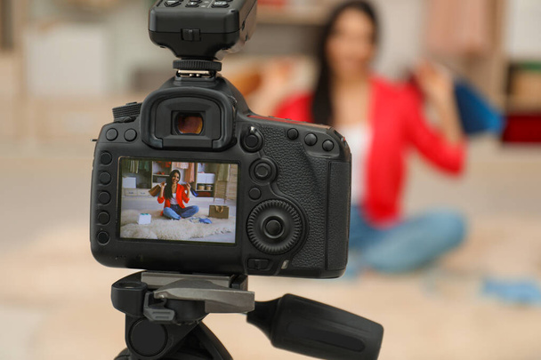 Fashion blogger recording new video in room, focus on camera - Фото, изображение