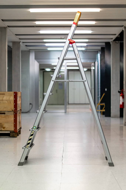 V σχήμα ανοικτή σκάλα στέκεται σε ένα διάδρομο εργαστήριο i διάδρομο - Φωτογραφία, εικόνα
