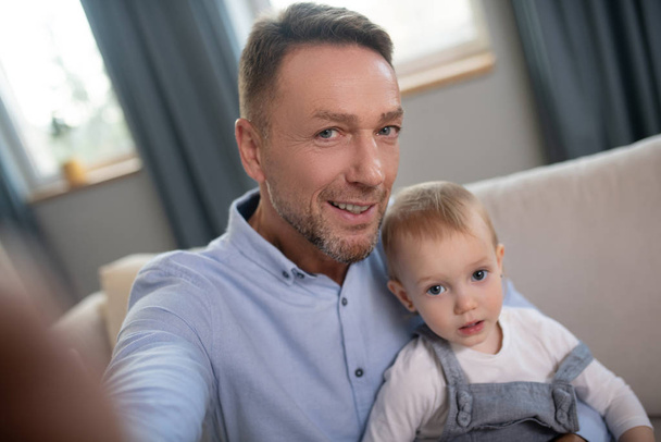 Mature father making selfie at home with his kid - Foto, Imagem