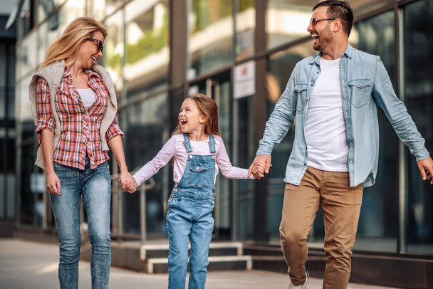 glücklich lächelnde Familie mit Tochter im Freien - Foto, Bild