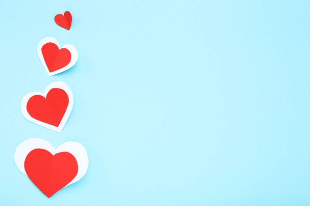 Red and white paper hearts on blue background - Foto, Imagem