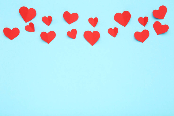 Red paper hearts on blue background - Fotoğraf, Görsel