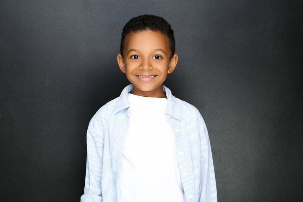 Young African American boy on black background - Foto, imagen
