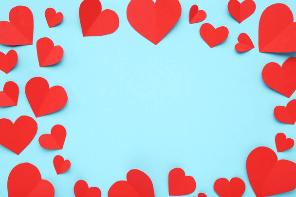 Red paper hearts on blue background - Foto, afbeelding