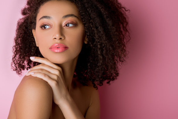 portrait of attractive curly nude african american girl on pink - 写真・画像