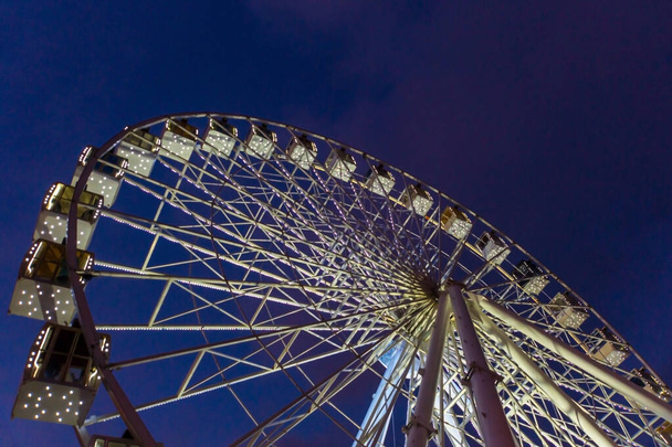 Ferris Wheel в розважальному парку пізно ввечері з сяючим світлом - Фото, зображення