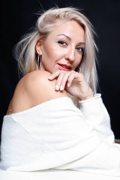 Portrait of a beautiful young attractive woman in a white sweater - Фото, изображение