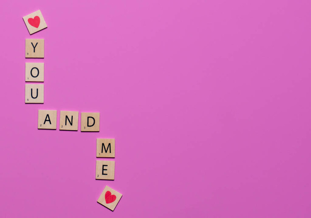 Kleurrijke jij en ik spel tegels met harten op een roze achtergrond om liefde te vieren - Foto, afbeelding