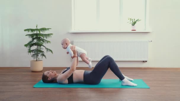 Mom does fitness with the baby at home - Πλάνα, βίντεο