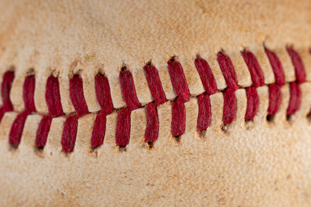 Крупный план старого, грязного бейсбола с красными швами
. - Фото, изображение