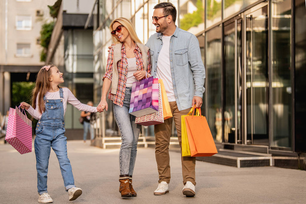 Счастливая семья веселится на свежем воздухе после шопинга
 - Фото, изображение