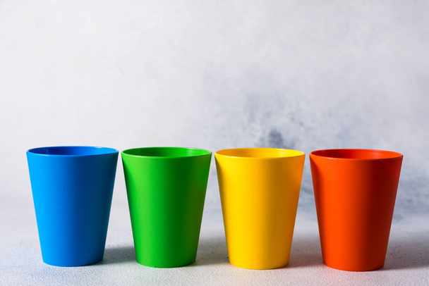 csoport színes műanyag poharak szürke kő háttér műanyag hulladék - Fotó, kép