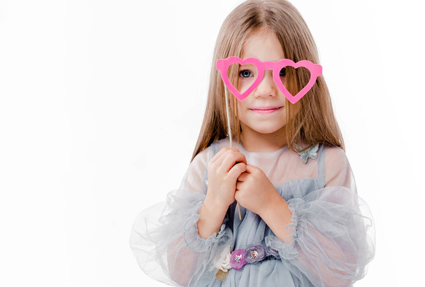 Beautiful girl in a gray dress and glasses made of cardboard in the form of hearts - Foto, Imagen